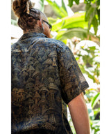 Person wearing a patterned shirt with a tropical background