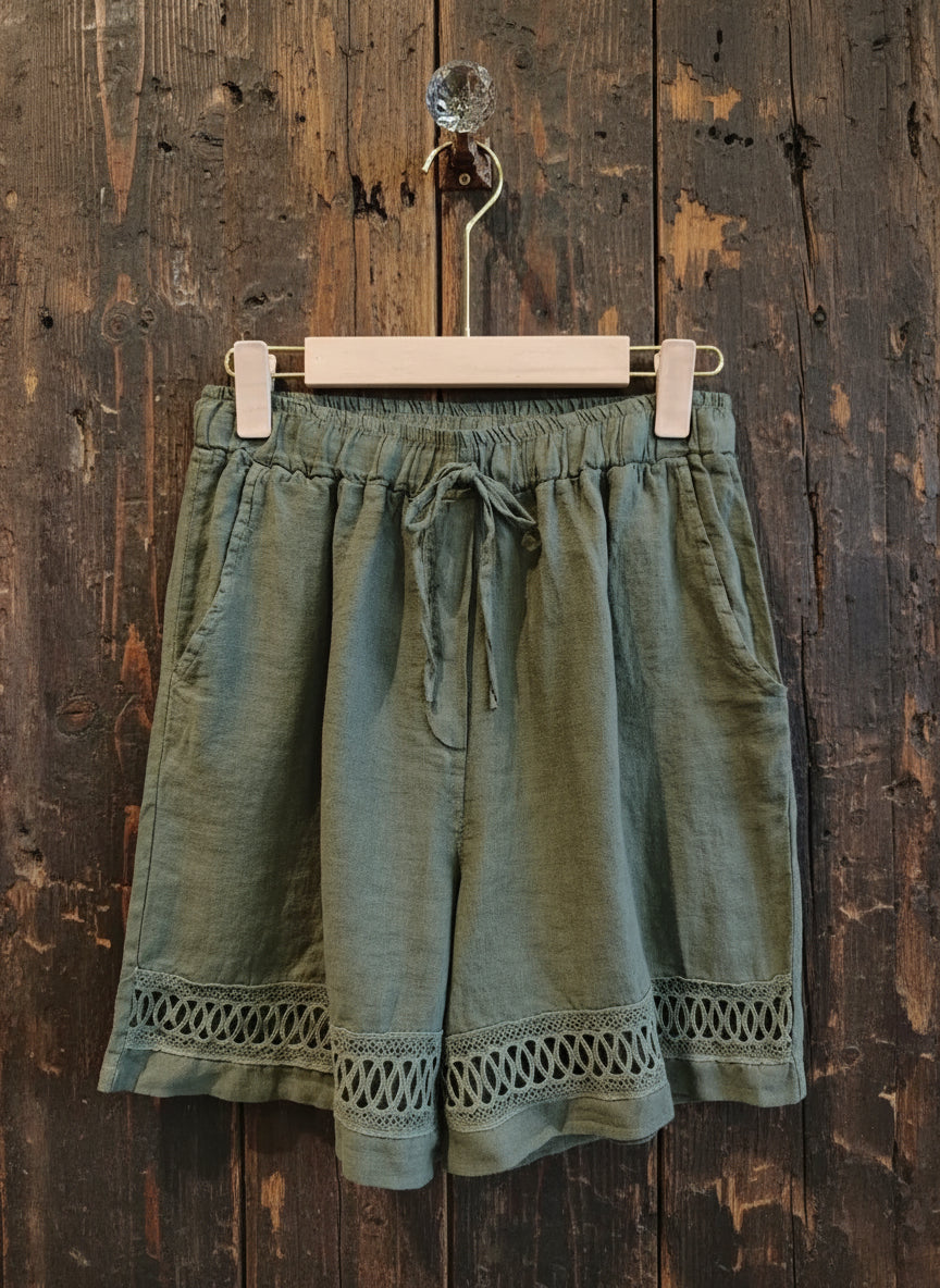 army shorts hanging against a wall