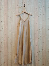 beige linen dress hanging against a wall