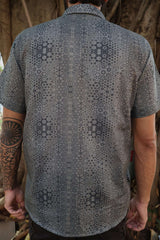 man in button p shirt with geometric print