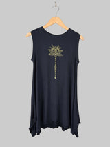 Black sleeveless top with a decorative design on a hanger against a neutral wall.