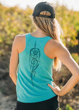 Person wearing a teal tank top with a black design outdoors