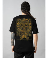 Person wearing a black t-shirt with gold intricate design on the back against a gray background