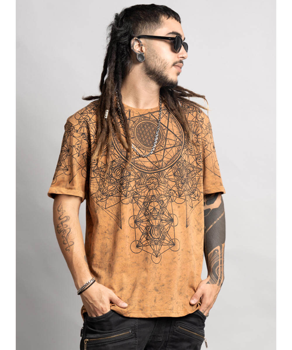 Man wearing a brown t-shirt with intricate black designs on a plain background