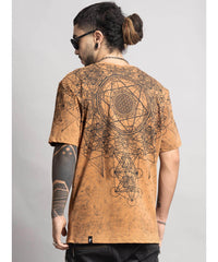 Man wearing a brown t-shirt with intricate designs on the back, standing against a plain background.