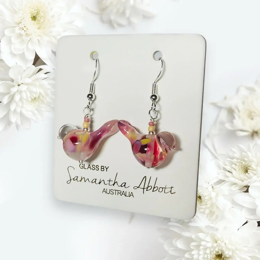 Glass earrings by Samantha Abbott on a branded card with white flowers in the background