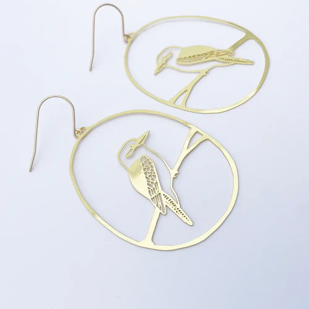 Gold bird-shaped earrings on a light gray background