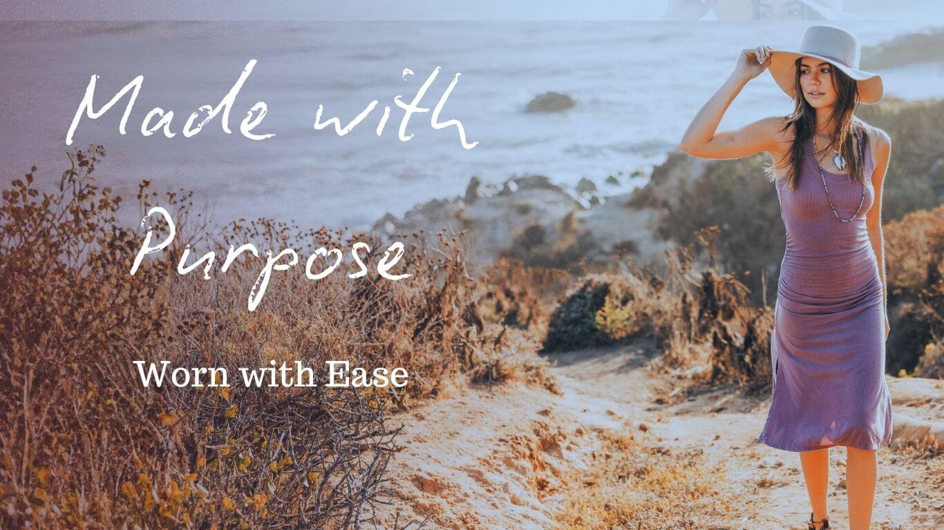 Woman in a purple dress and hat standing on a beach with text overlay 'Made with Purpose, Worn with Ease'.