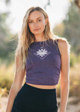 Woman wearing a purple tank top with a white geometric design outdoors