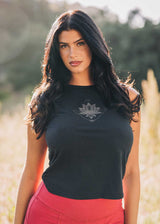 Woman wearing a black top with a lotus flower design in an outdoor setting