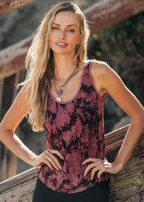 Woman wearing a patterned tank top standing outdoors with a blurred background