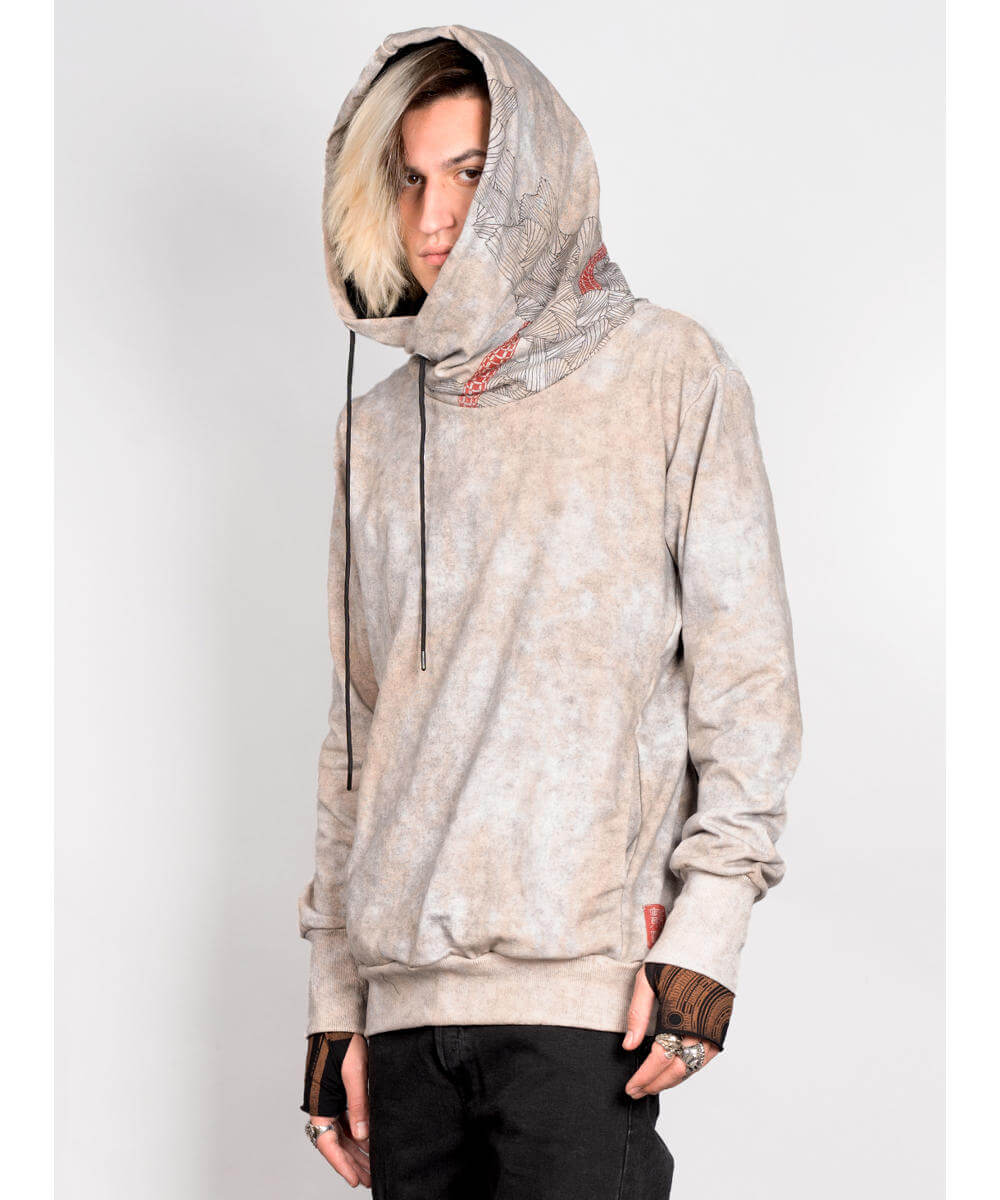 Person wearing a beige tie-dye hoodie with a white background