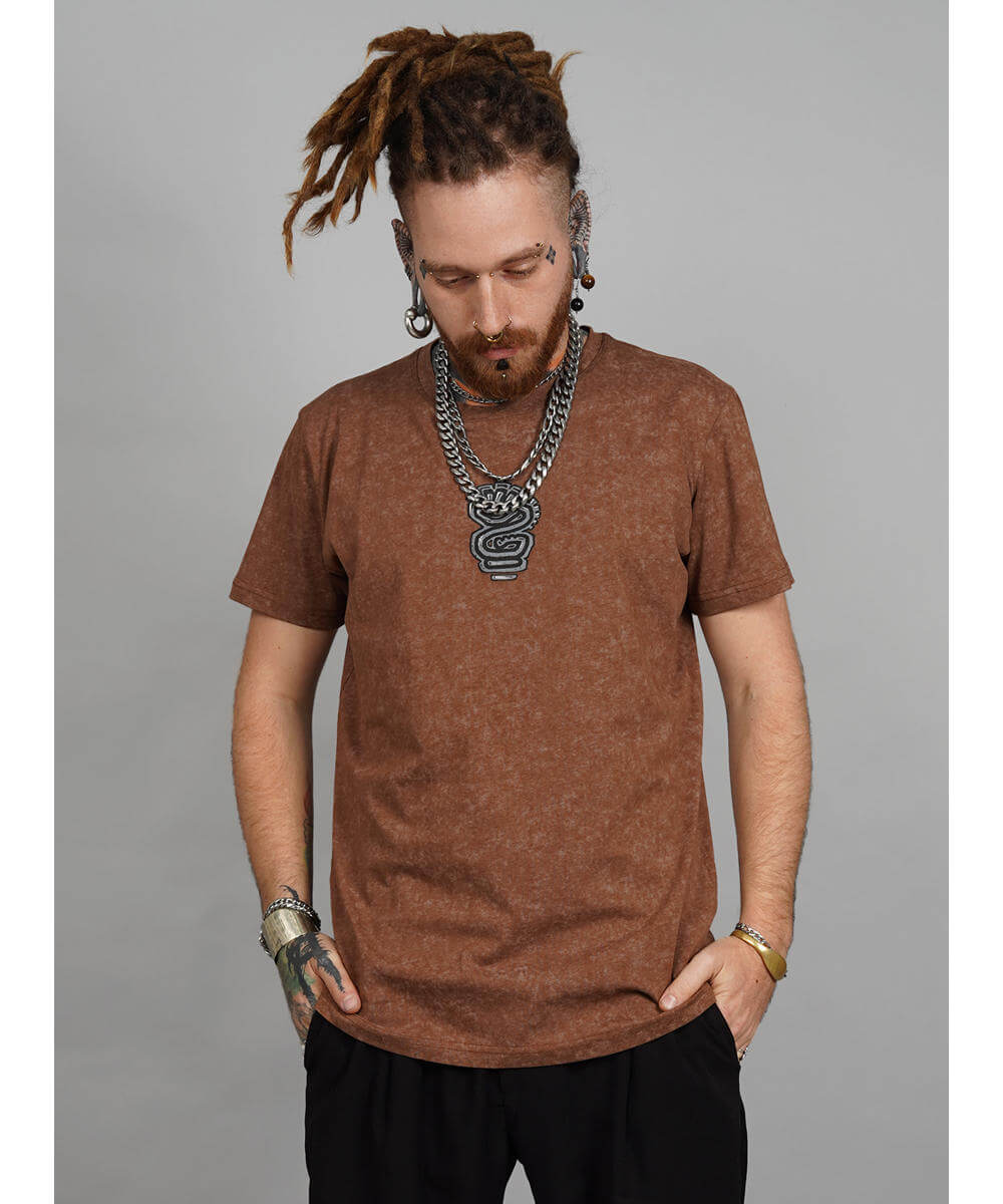 Man wearing a brown t-shirt and black pants with a gray background