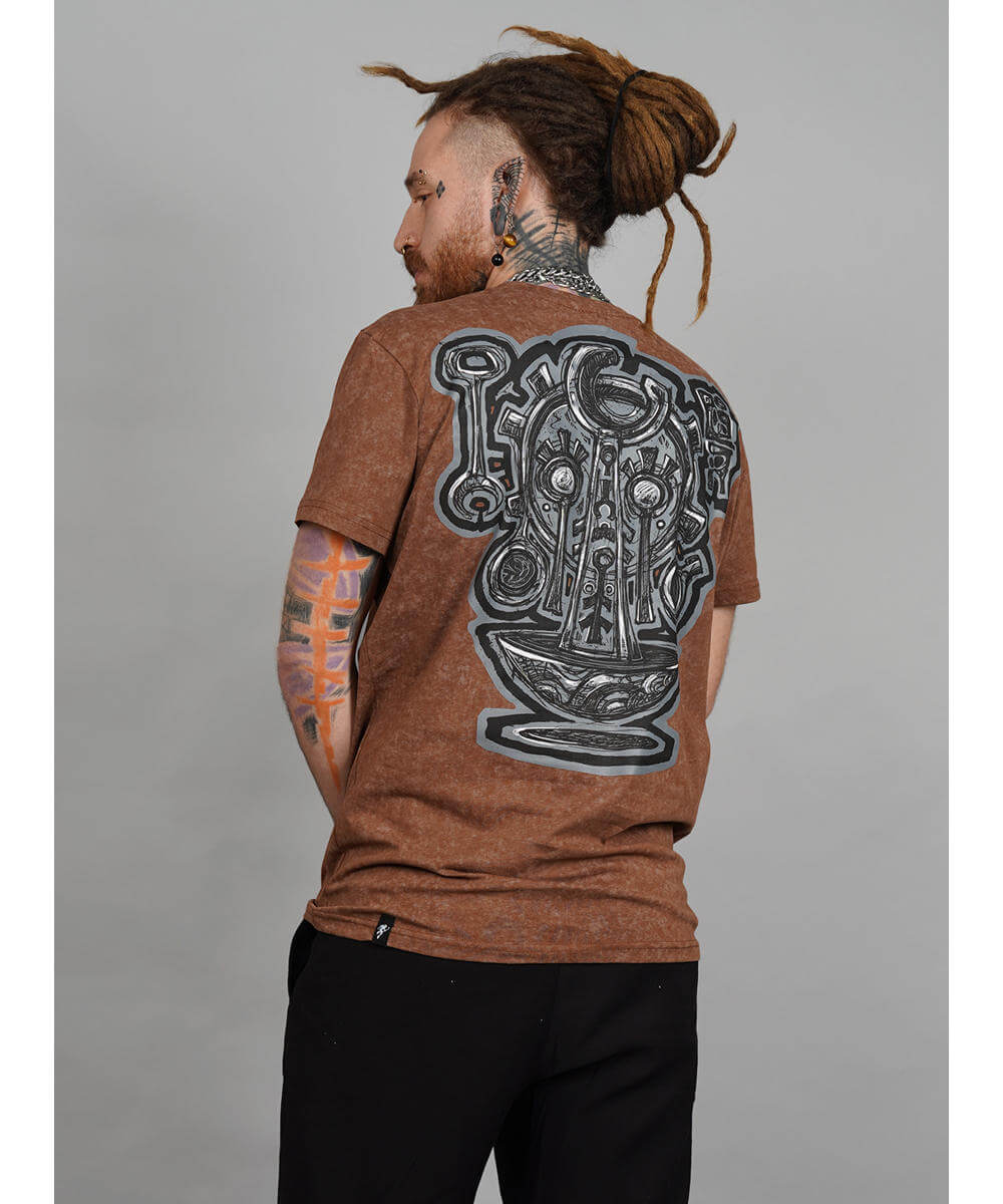 Person wearing a brown t-shirt with a large black graphic design on the back against a gray background