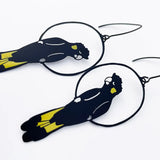 Black and yellow fish-shaped earrings on a white background