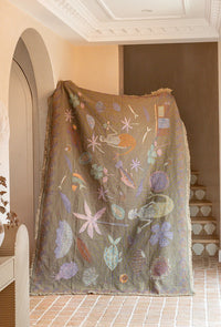 Recycled cotton Abundance throw blanket in peach with decorative nature-inspired artwork for beds and sofas