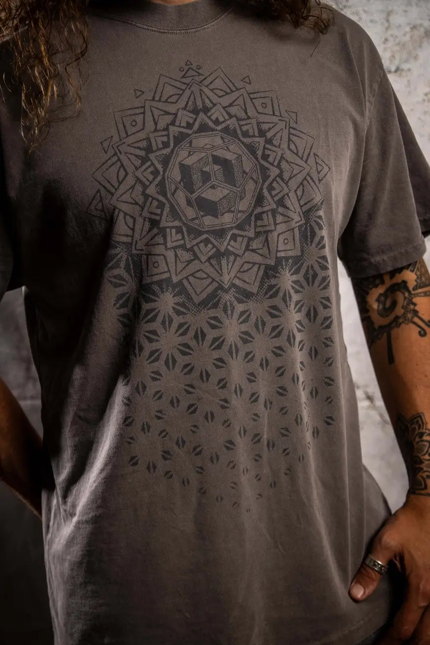 Person wearing a gray t-shirt with a geometric pattern