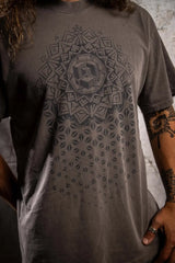 Person wearing a gray t-shirt with a geometric pattern