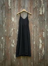 black dress on hanger on a wooden wall
