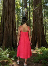 lady in coral colour dress in a forest of big trees