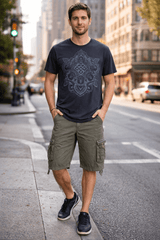 Man wearing a black t-shirt with a geometric design and green cargo shorts on a city street.