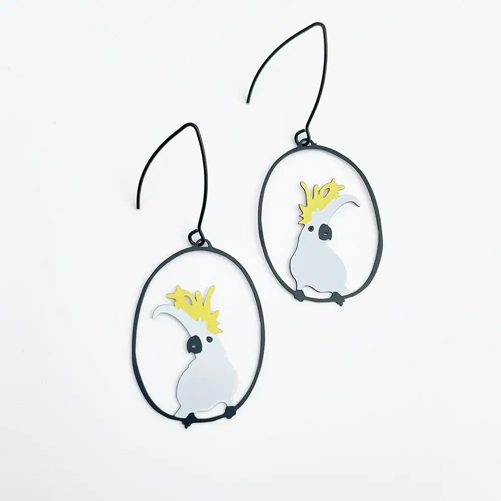 Pair of earrings with cockatoo designs on a white background