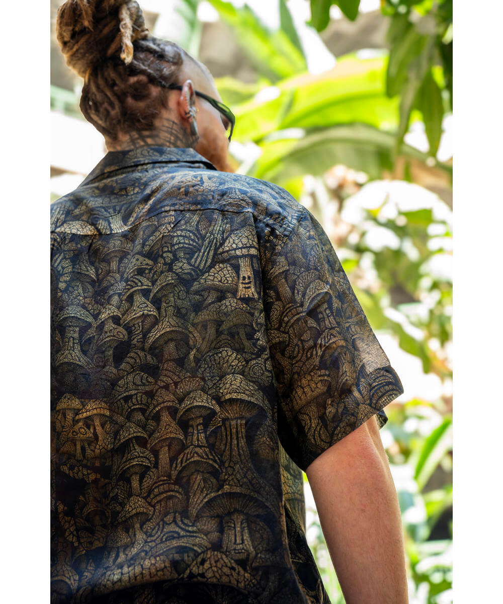 Person wearing a patterned shirt with a tropical background