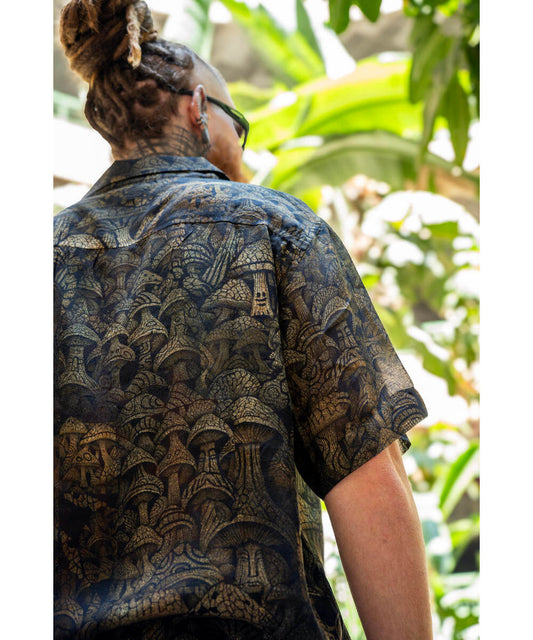 Person wearing a patterned shirt with a tropical background