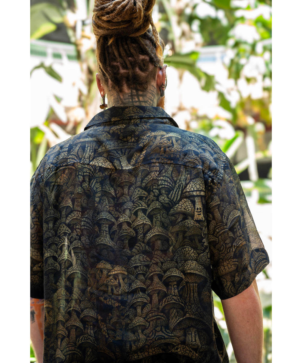 Person wearing a patterned shirt with a blurred natural background