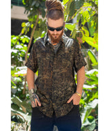 Man wearing a patterned shirt and sunglasses in a forest setting