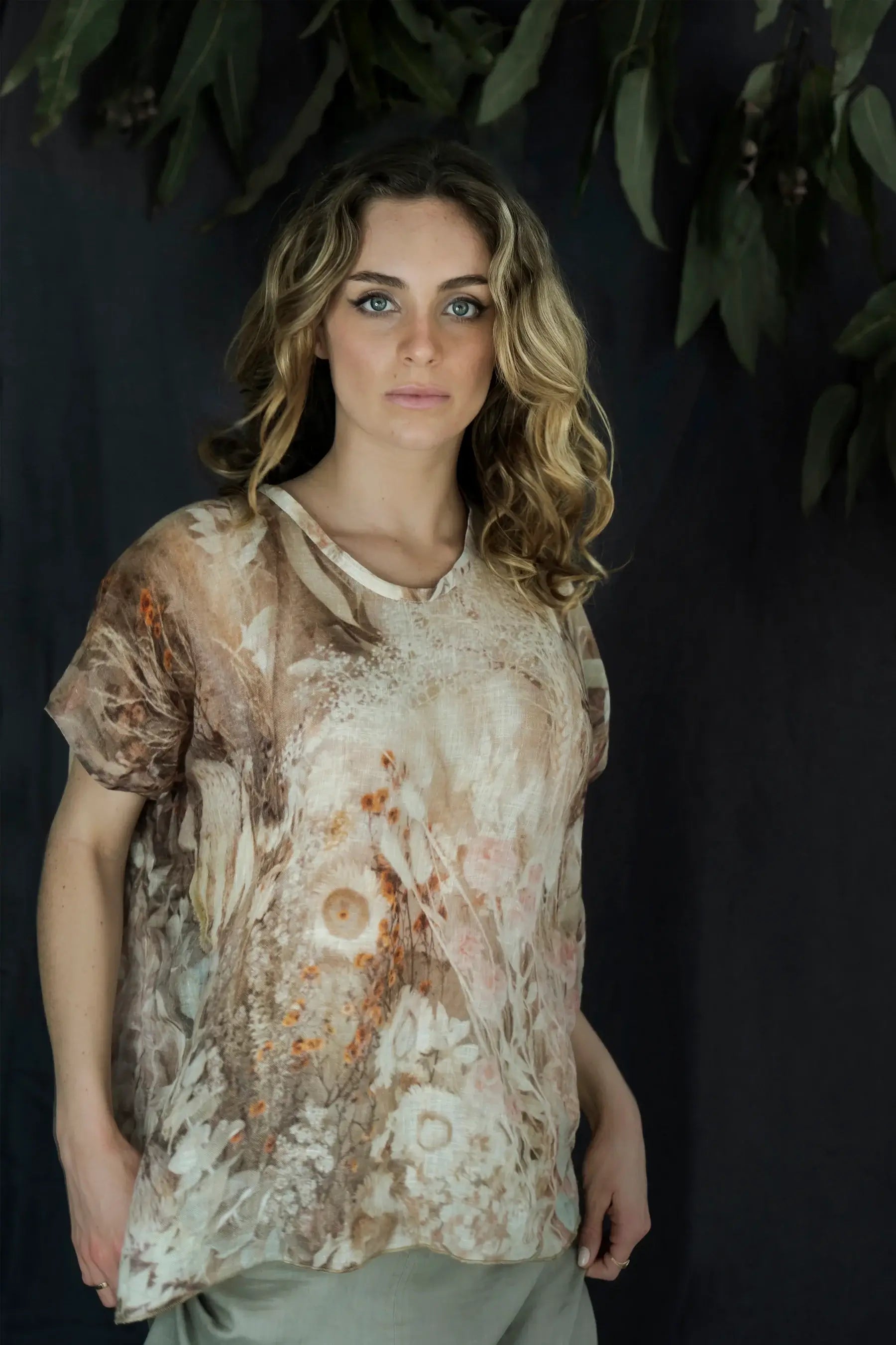 Woman wearing a floral blouse against a dark background