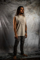 Man wearing a sleeveless beige top with intricate patterns against a textured gray background