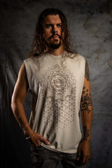 Man wearing a sleeveless shirt with a geometric design against a textured wall.