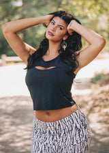 Woman wearing a black crop top and patterned pants outdoors