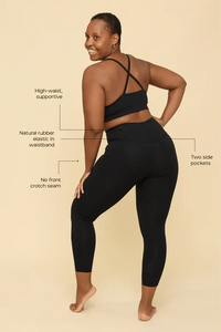 Woman wearing black athletic leggings with text highlighting features on a beige background