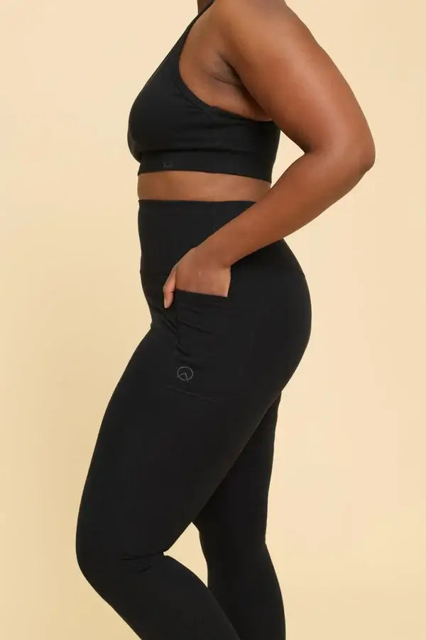 Person wearing black athletic outfit on a beige background