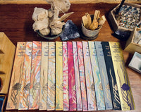 A selection of incense packets laid out on a surface, each with unique artwork and a variety of colors.