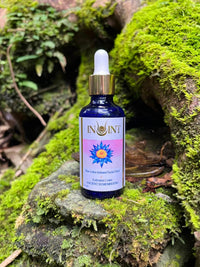 Bottle of Inoint elixir oil on a mossy rock with a natural background