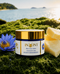 Jar of Blue Lotus Tallow with a blue flower and soap on green grass by a body of water