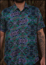 Person wearing a patterned shirt with a dark background