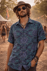 Man wearing a patterned shirt and hat at a music festival.