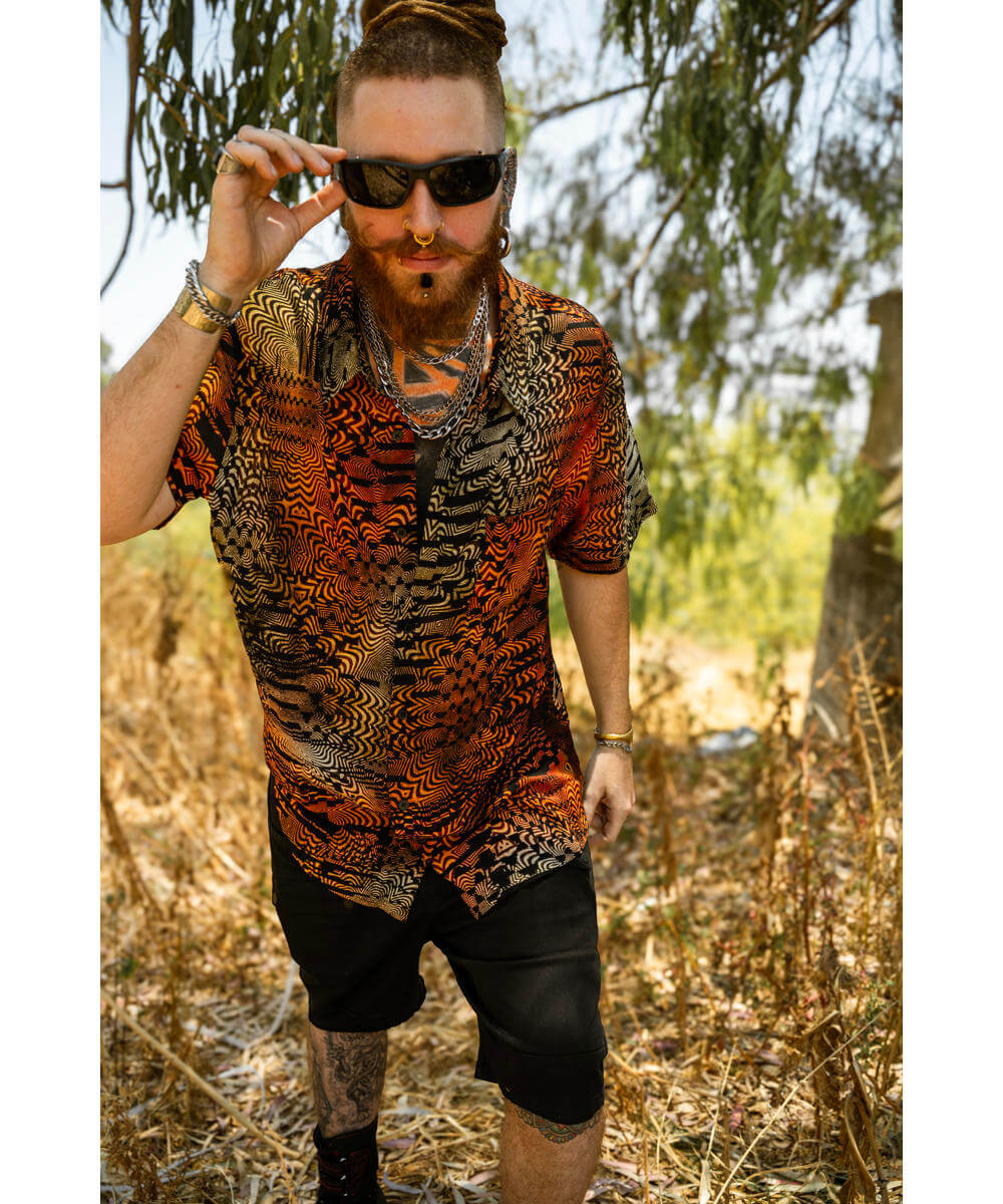 Man wearing a patterned shirt and sunglasses in a natural setting