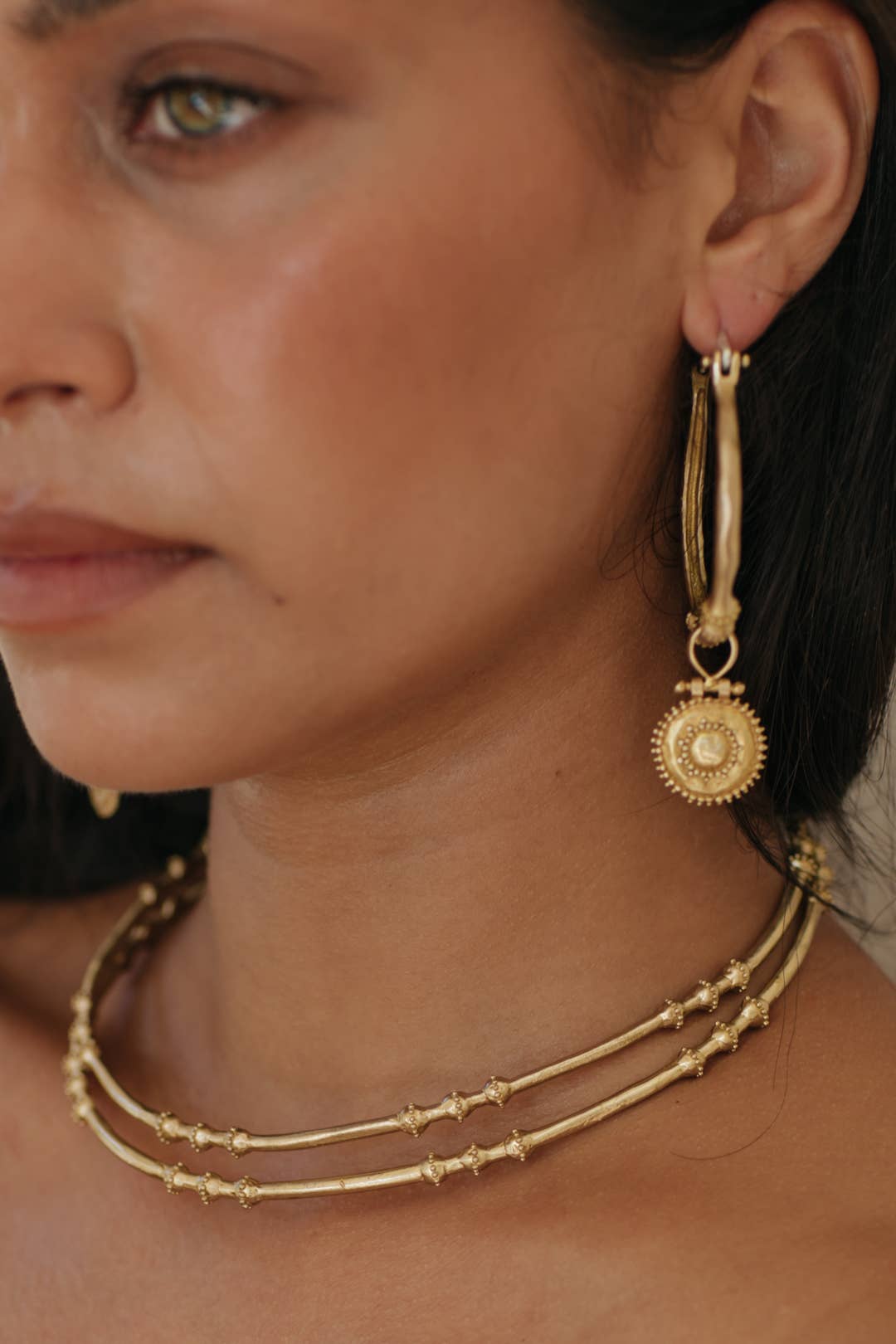 Kavani Hoops - Brass worn as textured statement earrings with round decorative trinkets