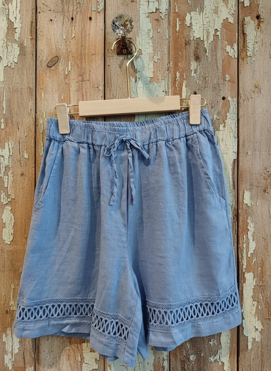 blue shorts hanging against a wall
