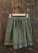 army shorts hanging against a wall