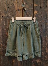 army shorts hanging against a wall