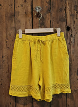mustard shorts hanging against a wall