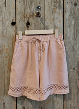 rose shorts hanging against a wall