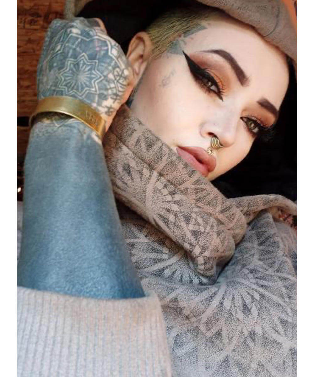 Person wearing a patterned scarf and hat with a blurred background