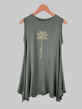 Green sleeveless top with a floral design on a hanger against a tiled wall.